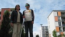 Beim Selbstversuch merkt Reporter Willi, wie schwer es ist, sich ohne Augenlicht zurechtzufinden. Zum Glück hilft ihm Mobilitätstrainerin Gerda, sich mit dem Blindenstock zurechtzufinden. | Bild: BR/megaherz gmbh/