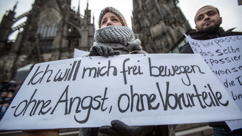 Eine Frau protestiert am 10.01.2016 in Köln (Nordrhein-Westfalen) vor dem Hauptbahnhof und dem Dom gegen sexuelle Gewalt mit einem Plakat "Ich will mich frei bewegen - ohne Angst, ohne Vorurteile". Nach den sexuellen Übergriffen auf Frauen in der Silvesternacht verstärkt die Polizei die Präsenz am Hauptbahnhof. Foto: Maja Hitij/dpa | Bild: picture alliance / dpa | Maja Hitij